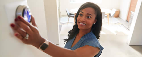 Woman adjusting a HVAC thermostat